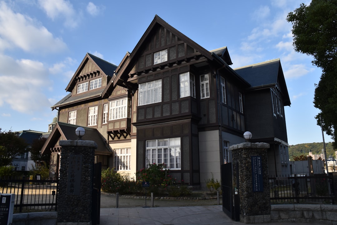 dark-wooden-house-with-white-windows-and-stone-pillars-bqt2ovtaglo