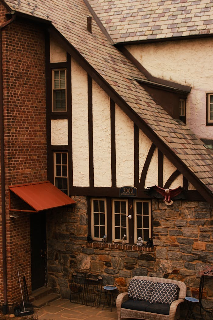 Tudor-style house facade featuring brick, stone, and timber elements, showcasing classic architecture.